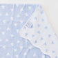Baby blanket with heart pattern and brand tag on a light blue background