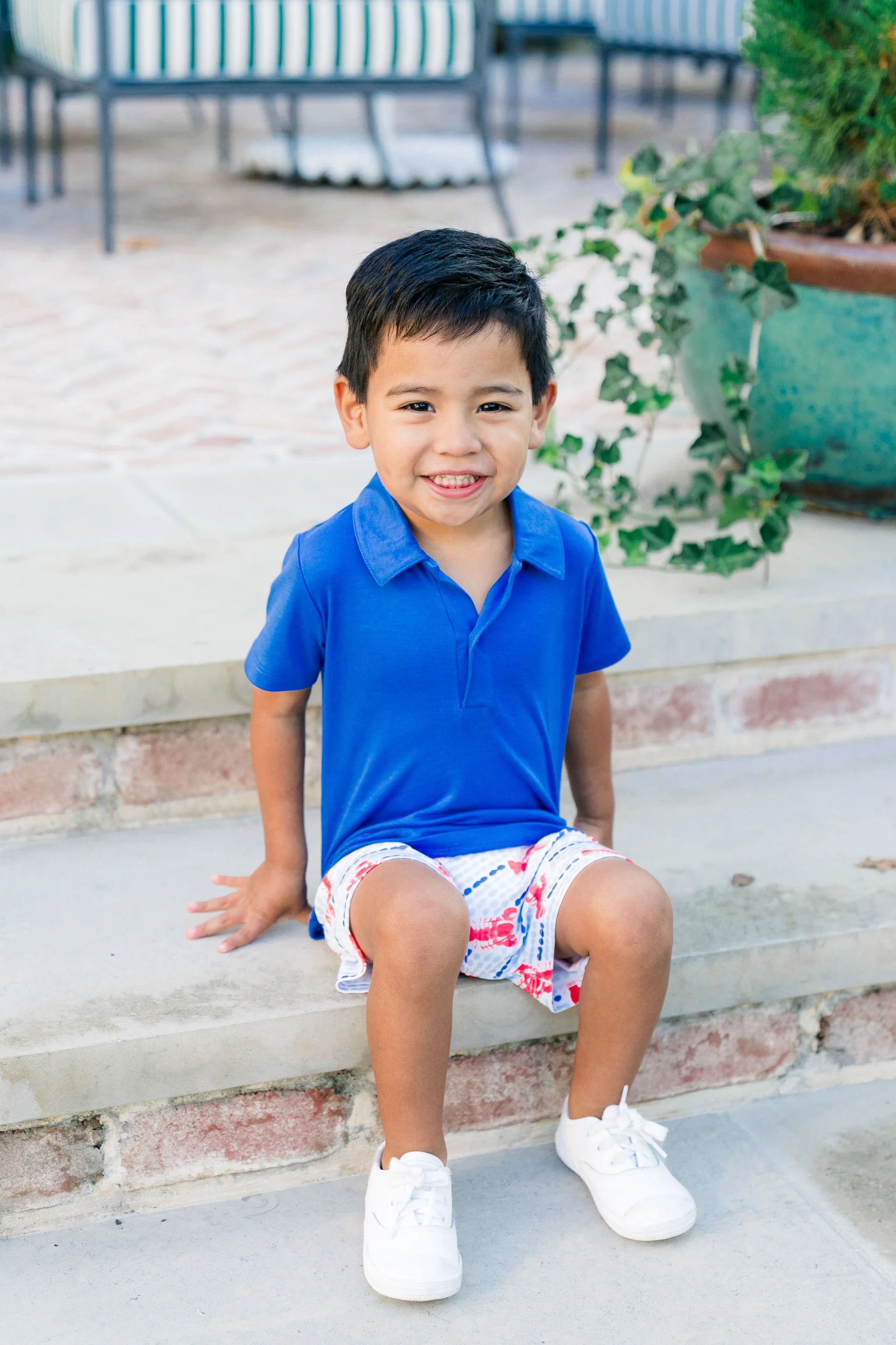 Blue short sleeve polo styled with blue and white shorts with red lobster pattern