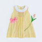 Yellow dress with pink bow and tulip on a white background