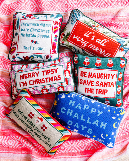 Set of decorative pillows with humorous sayings on a pink blanket
